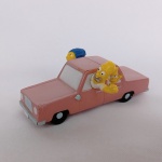 Miniatura do carro da Familia dos Simpsons com os personagens Homer, Marge, Liza e Bart nas janelas. Fabricado em resina e desmontável no meio. Mede 8cm de comprimento quando montado