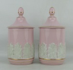 Par de potes para algodão em porcelana com marca da manufatura na base, na cor rosa com trabalhos em relevo de folhas. Frisos em dourado. Alt. 20,5 cm.