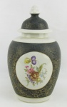 Potiche em porcelana decorada com pinturas florais em policromia e em reserva. Delicados trabalhos em dourado. Alt. 35,5 cm.
