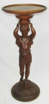 Blackamoor em madeira entalhada, na forma de figura sustentando tampo circular. Med. 87,5x38 cm