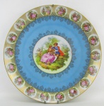 Medalhão em porcelana alemã - Bavaria, decorada com cena de galanteio ao centro e na aba, com diversa cenas. Diam. 33,5 cm.