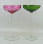 Par de taças de coleção de pé alto, em cristal, sendo uma na tonalidade rosa e a outra verde. Alt. 15 cm.
