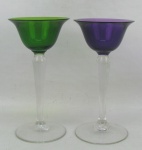 Par de taças de coleção de pé alto, em cristal, sendo uma na tonalidade verde e a outra lilás. Alt. 12,5 cm.