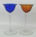 Par de taças de coleção, de pé alto, em cristal, sendo uma na tonalidade azul e a outra salmão. Alt 12,5 cm.