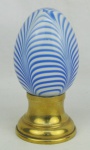 Pinha em murano na cor leitosa, decorada internamente com trabalhos na cor azul. Base em metal banhado de dourado. Alt. total 16,5 cm.