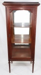 Vitrine estilo francês Luis XVI, em madeira entalhada. Porta e laterais com vidros. Parte interna com espelho. Med. 157x68x43 cm.