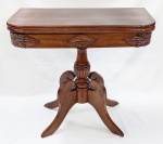 Console em jacarandá entalhado, com tampo dobrável que quando aberto pode ser usado como mesa. Tampo se apoia sobre coluna torneadas de onde partem 4 pés recurvos. Marcas de uso no verniz. Med. fechado 76x80x40 cm.