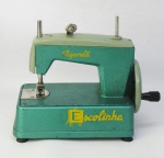 Antiga máquina de costura de coleção para criança, com marca da manufatura Vigorelli, em metal com pintura esmaltada, nos tons de verde. Funcionando e na caixa original. Med. máquina 16x20,5x10 cm.