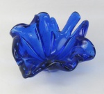 Cinzeiro em murano na cor azul cobalto, na forma de folha com trabalhos em gomos e internamente com bolhas de ar. Med. 9x22x18 cm.