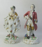 Par de estatuetas em porcelana policromada, representando  "Casal de nobres". Base com flores em alto relevo. Pequenas perdas no dourado. Alts. 20 cm.