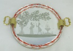 Bandeja circular em espelho veneziano, decorada com lapidações em satiné, representando paisagem com casal em cena romântica. Borda em murano com trabalhos torneados. Alças em bronze. Med. 4x33x27 cm.
