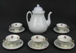A) Grande bule em porcelana inglesa, com marca da manufatura Royal Patent Ivonstone Thomas Hugles & Son na base. Ponta do bico com fio de cabelo. Alt. 25,5 cm.B) Cinco xícaras para chá em porcelana polonesa, com decoração floral em policromia. Alt. xícara 5,5 cm.
