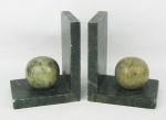 Serre livres em pedra sabão, adornados com bolas em alto relevo. Apresentam pequenas batidinhas nas bordas. Meds. 13x10,5x7,5cm.