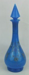 Garrafa em opalina soprada no tom azul, decorada com pintura floral policromada. Detalhes esmaltados em relevo. Alt. 39,5cm.