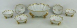 Conjunto de saladeira e 6 bowlzinhos em porcelana com marca da manufatura no verso, decorados com pintura floral em policromia. Detalhes em dourado, tendo estes minúsculos desgastes. Med. saladeira 9,5x20cm.