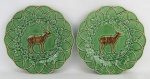 Par de pratos em faiança portuguesa no tom verde, com marca da manufatura Bordallo Pinheiro no verso, decorado ao centro com figura de cervo em relevo. Diam. 24cm.