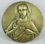 Placa sacra, circular, de mesa, em bronze dourado, representando "Sagrado Coração de Jesus". Diam. 24,5cm.