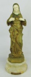 Eugene Bernoud - Escultura em bronze francês patinado de dourado, com mãos e rosto em marfim. Assinada na parte de trás. Base em ônix, contendo placa com o título "Sacre Coeur de Marie". Alt. total 35cm.