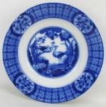Prato em porcelana inglesa, azul borrão, com marca da manufatura Johnson Bros, decorado com pintura de paisagem com aves. Borda com flores e arabescos. Diam. 22,5cm.