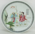 Medalhão em porcelana chinesa, com marca da manufatura no verso, decorado com pintura de cena do cotidiano em policromia, com detalhes esmaltados e inscrições. Diam. 26,5cm.