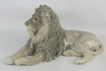 Estatueta de coleção em porcelana Dinamarquesa, com marca da manufatura representando "Leão em repouso". Med. 16,5x32x15cm.