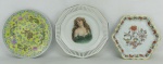 Três pratos decorativos, em porcelana policromada, sendo um português com marca da manufatura Vista Alegre, com pintura de flores e pássaros, um alemão - Bavaria, tendo ao centro busto de dama, e o outro em porcelana chinesa com pintura floral e dragões. Diam. maior 21 cm. Diam. menor 18x20 cm.