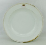 Prato brasonado em porcelana francesa. Brasão não identificado e monograma não visível. Perdas nos frisos dourados. DIam. 23cm.