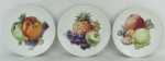 Três pratos decorativos em porcelana tcheca, tendo ao centro em policromia frutas diversas. Diam. 20cm.