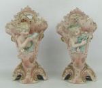 Belo e antigo par de floreiras decoradas ao estilo art-noveau, em biscuit europeu, policromado, com trabalhos em relevo, adornados com uma figura de criança tocando musica e surgindo do seu interior, em alto relevo. Detalhes em dourado. Alt. 18,5cm.