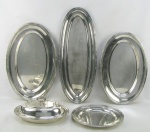Cinco peças de baixela em metal espessurado a prata, sendo terrina com tampa, travessa oval e bandeja circular da manufatura Fracalanza, e 2 travessas ovais da manufatura Wolff Prata 90. Minúsculas marcas de uso. Med. travessa maior 61x23,5cm.