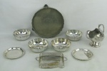 Nove peças em metal espessurado a prata de diversos modelos, decorações e procedências, sendo açucareiro com colher, salva, 4 bowlzinhos, bandejinha e 2 porta copos. Bowlzinhos e bandejinha com desgastes no prateado e açucareiro com pequena mossa na base. Alt. açucareiro 13,5cm e Diam. salva 21cm.