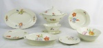 Aparelho de jantar em porcelana alemã, com marca da manufatura Kahla, com decoração de pintura floral em policromia, composto de sopeira, terrina com tampa, 2 legumeiras, 2 saladeiras, 3 travessas ovais, prato para bolo, molheira, 48 pratos rasos, 22 fundos e 17 para sobremesa. Um prato raso, um fundo e um para sobremesa com bicado na borda, uma legumeira e uma saladeira com fio de cabelo. Total 98 peças.