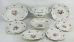 Aparelho de jantar em porcelana polonesa, com marca da manufatura Tielsch Walbrzych no verso, com decoração floral em policromia, composto de terrina com tampa, saladeira, 3 travessas ovais, 24 pratos rasos, 12 fundos e 12 para sobremesa. Dois pratos rasos com bicado na borda e um fundo com fio de cabelo. Total de 53 peças. Med. travessa maior 42,5x28,5cm.