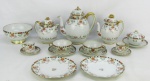 Aparelho para chá e café em fina porcelana oriental, decorado com pintura floral em policromia e detalhes em dourado, composto de 2 bules, leiteira, açucareiro, bowl para biscoitos, 4 pratos para sobremesa, 6 xícaras para chá e 3 para café. Bowl e uma xícara para café com fio de cabelo. Um prato para sobremesa com bicado na borda e tampa do bule menor, adaptada. Total 18 peças. Alt. bule maior 20cm.
