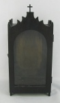 Oratório em madeira com parte superior trabalhada com recortes e encimado com uma cruz. Porta e laterais com vidro. Ponta de um recorte com restauro. Med. 34,5x16x12cm.