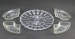 Cinco peças sendo prato para bolo em cristal lapidado e 5 petisqueiras em vidro prensado. Prato com pequeno bicado. Diam. prato 30cm. Med. petisqueira 4x19,5x20cm.