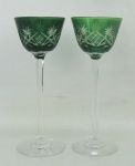 Duas taças de pé alto para licor em cristal europeu no tom verde, decoradas com lapidações de sulcos, tijolinho e estrelas. Hastes sextavadas. Alt. 13cm.