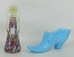 Duas peças, sendo porta objetos na forma de sapato, em opalina no tom azul com trabalhos de flores em relevo, e castiçal representando anjo, em murano policromado e decorado internamente com pó de ouro. Med. sapato 6x14,5x4cm e Alt. anjo 13,5cm.