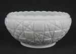 Bowl em milk glass decorado com trabalhos de sulcos em baixo relevo, formando geométricos. Borda com ondulações. Med. 10,5x21,5cm.