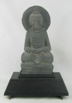 Escultura em argamassa representando "Buda". Base em madeira patinada. Alt. total 51cm.