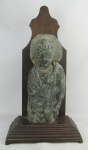 Escultura em argamassa representando "Buda". Base em madeira nobre entalhada. Apresenta perdas e pescoço colado. Alt. total 50cm.
