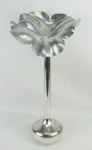 Solifleur em metal espessurado a prata, com marca da manufatura na base. Parte superior com trabalhos representando uma flor. Pequenos desgastes no prateado. Alt. 45,5cm.