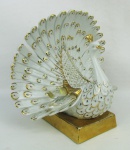 Escultura em porcelana italiana com etiqueta da manufatura Carpie, representando "Pavão". Decorado com apliques de cristal Swarovski. Detalhes em dourado. Base com pequenos desgastes no dourado e apresenta pequeno restauro de um lado da asa. Alt. 18,5cm.