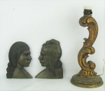 a) Par de bustos em madeira entalhada, representando "casal indígena". Alts. 20 e 18,5cm. b) Base para luminária de mesa em madeira patinada de dourado e entalhada com sulcos, folhagens e volutas. Desgastes na patina. Alt. 36cm.
