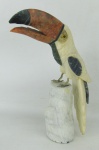 Escultura em pedra natural policromada, representando "Tucano". Olhos de vidro. Pés em metal. Alt. 26,5cm.