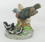 Garrafa para licor em biscuit policromado, adornado por esquilos e peru em relevo. Base apresenta as inscrições "Austim Nichols and Co. Wild Turkey 101 Proof Liquor Bottle Limited Edition Porcelain Wild Turkey and Skunks Nº 12 1986. Não contem bebida. Alt. 13cm.
