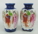 Par de vasos em porcelana oriental com decoração floral e cena com gueixas em policromia. Apresenta marca na base. Um com pequena colagem na borda. Alt. 12cm.