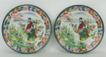 Par de pratos em porcelana oriental com marca no verso, decorados com pintura floral e cena de paisagem com gueixas em policromia. Diamts. 18,5cm.