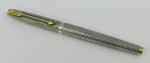 Caneta tinteiro americana em prata, com marca da manufatura Parker, trabalhada com frisos formando geométricos. Pena em ouro 14k. Necessita carga. Comp. 13cm.
