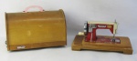 Máquina de costura para crianças, com marca da manufatura Leonan, em madeira e metal pintado. Funcionando e na caixa original. Med. máquina 13,5x27x16,5 cm. Med. com a caixa 21,5x27x16,5 cm.
